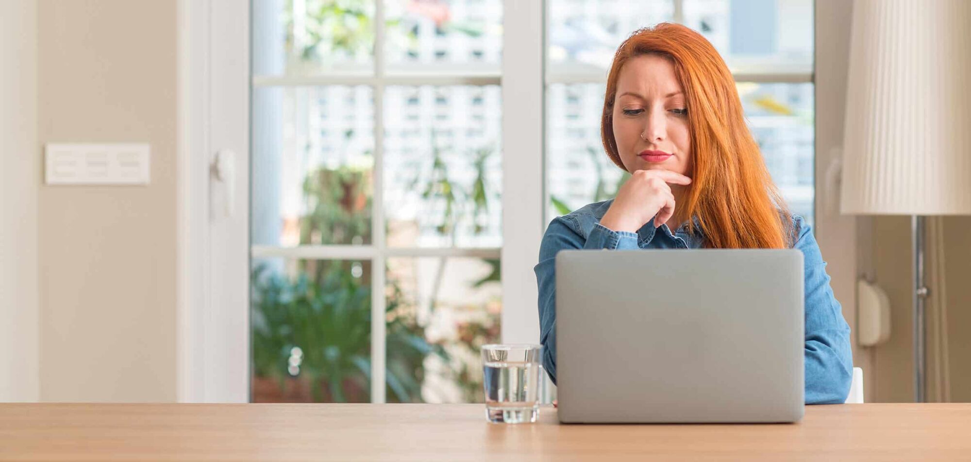 Dame rood haar achter laptop vrouw oranje haar met neuspiercing finzie website