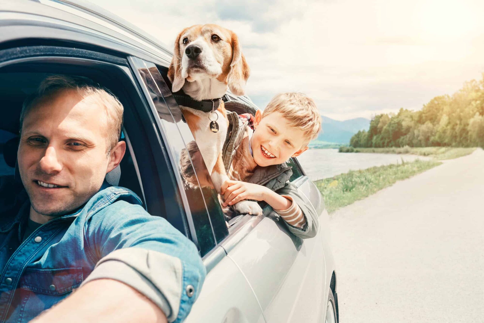 Vader, zoon en hond in auto op vakantie