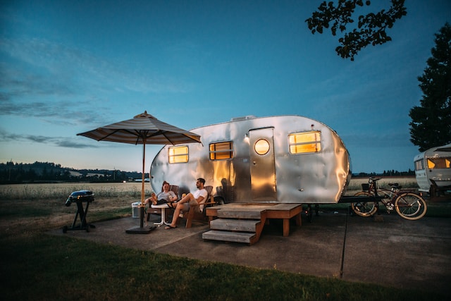 Caravan met 2 mensen die genieten van de avond