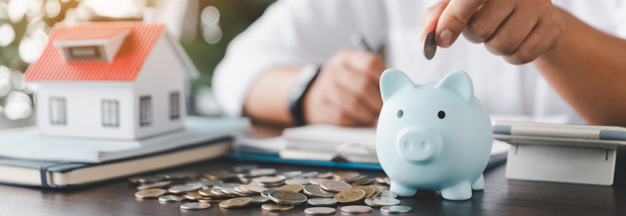 Saving investment home with loan finance money business concept. Investment banking finance for residential real estate business. Stack coins with model house for investment loans. Cash for taxes.