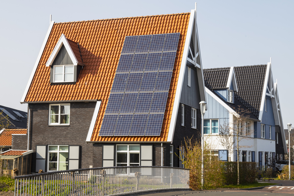 Solar panels on a new house with red roof.