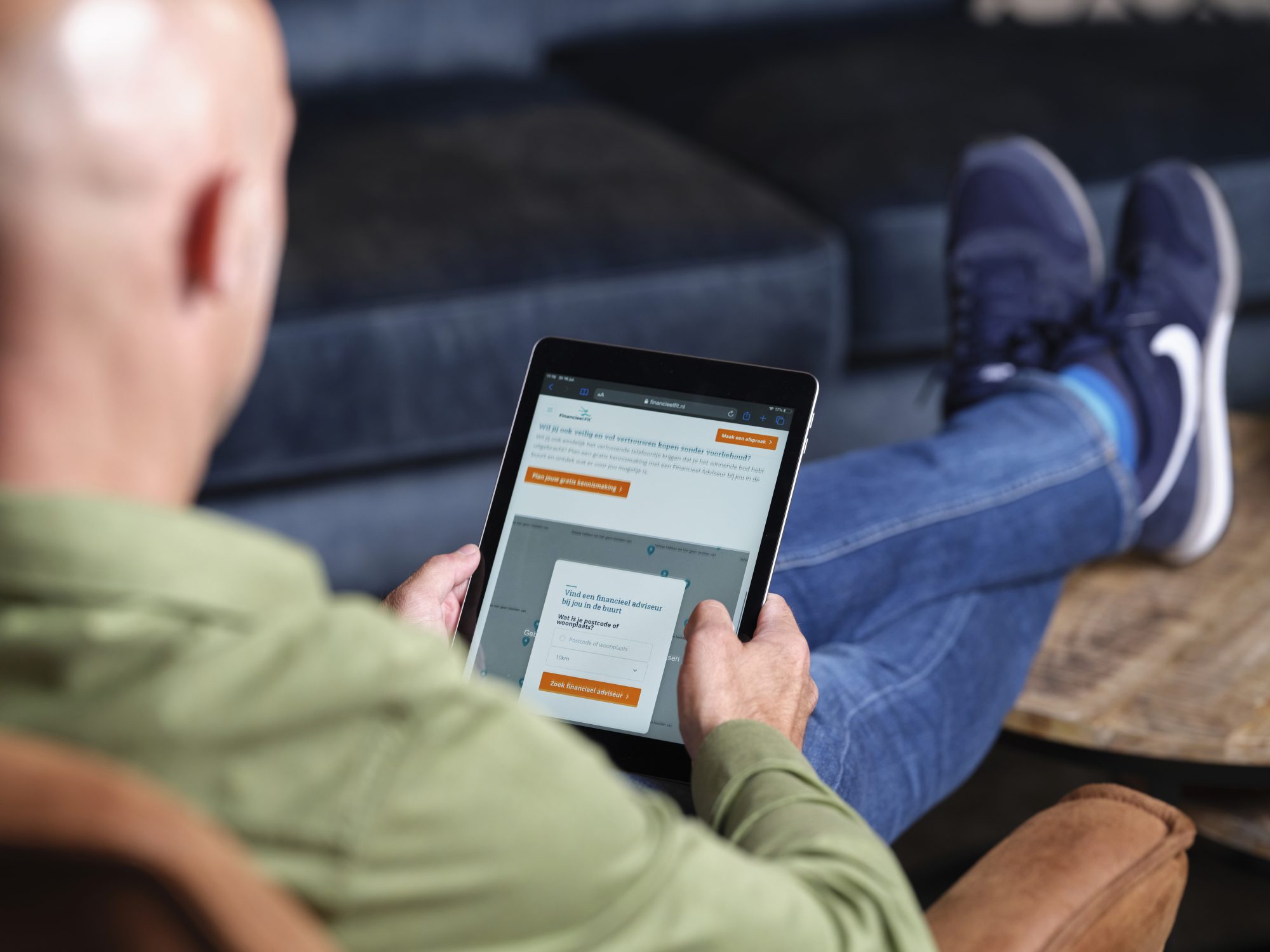 Man die op de bank ontspannen onderzoekt hoe hij zijn woonlasten kan verlagen