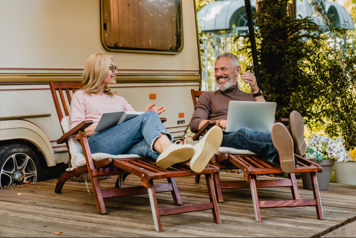 Echtpaar bespreekt financiële plannen voor later bij camper tijdens pensioenvoorbereiding.