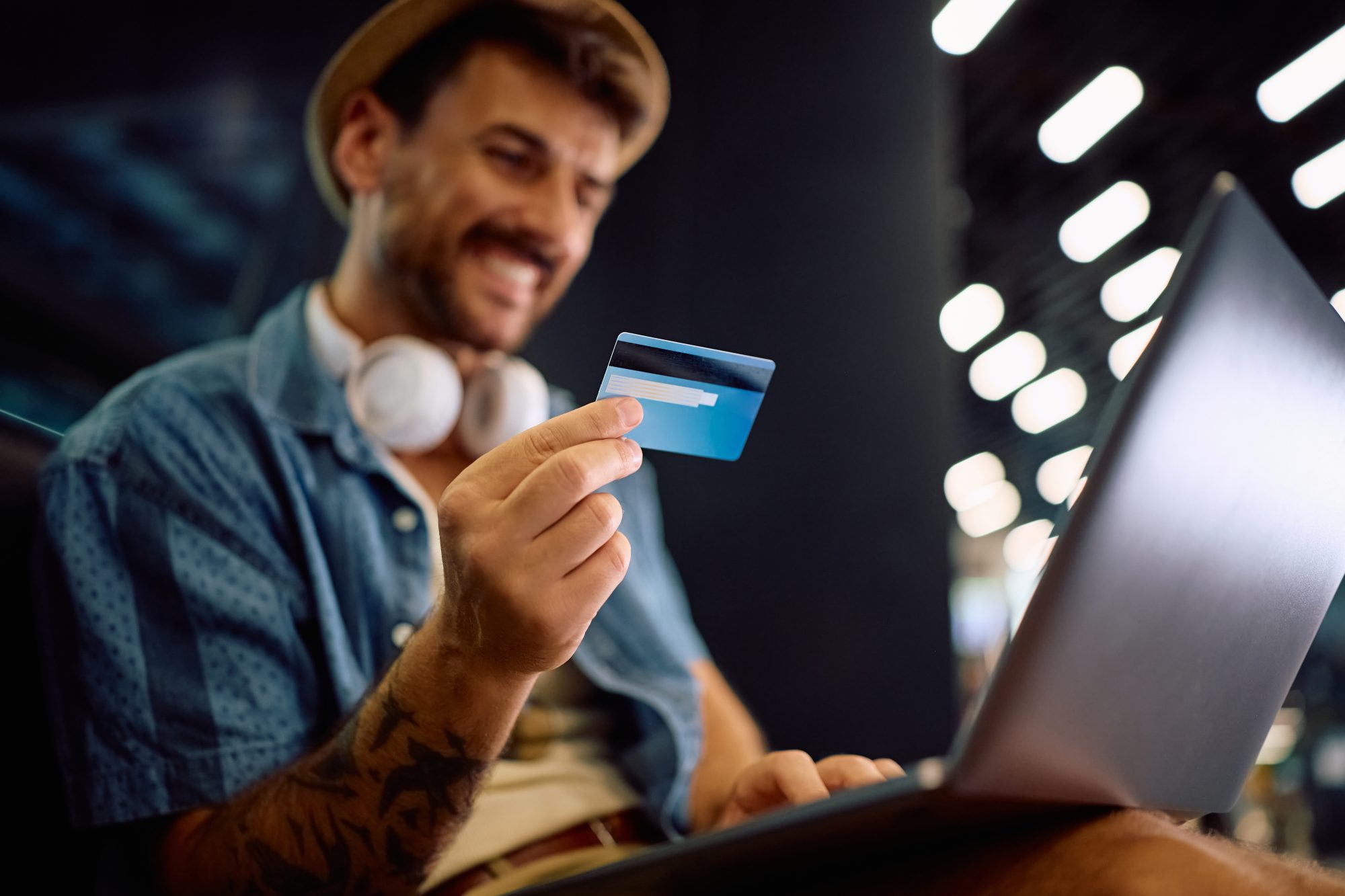 Man betaalt online met bankpas en laptop en denkt na over vakantiegeld slim besteden.